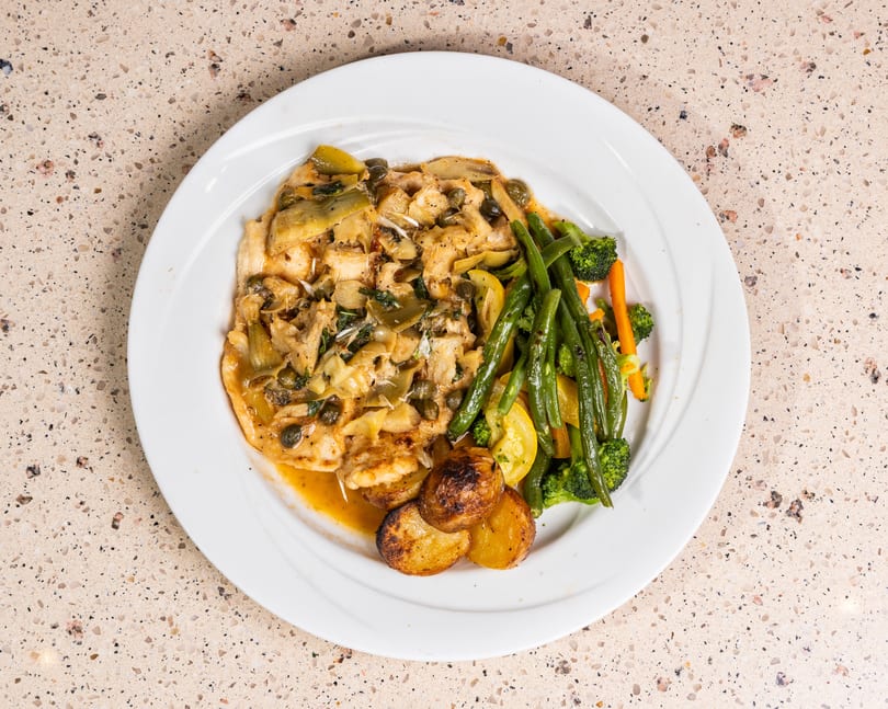 Chicken with artichokes, capers, roasted potatoes, and steamed green beans, broccoli, and yellow squash.